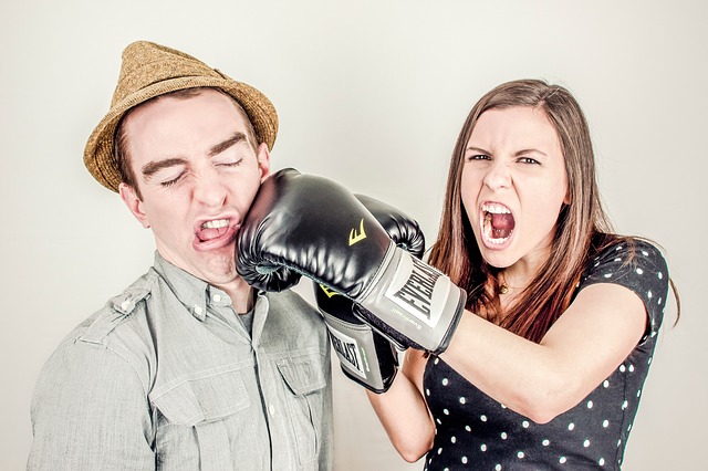pareja donde ella tiene guantes de boxeo y le da puñetazo a él