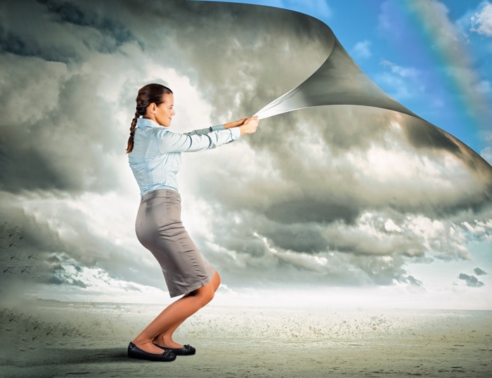 mujer destapando el cielo de una capa gris
