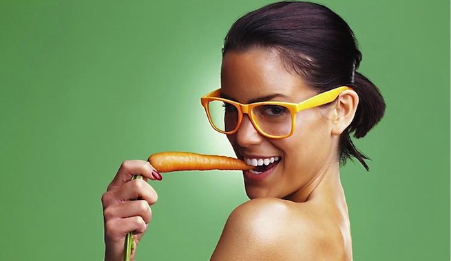 mujer mordiendo zanahoria con actitud sugerente