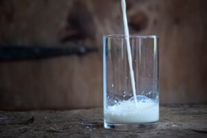 leche de vaca mientras se vierte en un vaso de cristal