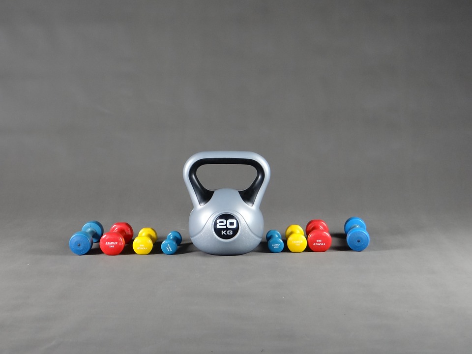 kettlebell de 20 kg con a los lados mancuernas de diversos colores y tamaño