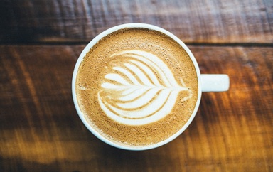taza de capuccino con espuma con dibujo