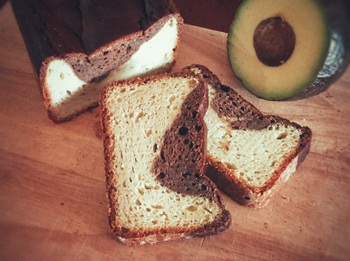 bizcocho de aguacate y algarroba cortado y aguacate partido al lado
