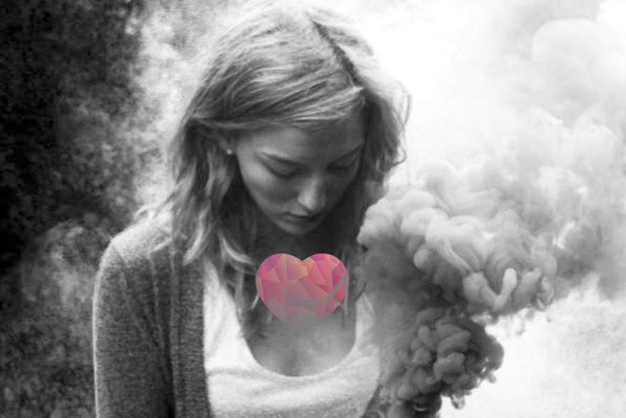 mujer cabizbaja con un corazón dibujado en el pecho y humo alrededor
