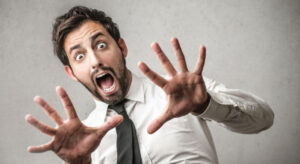 hombre con cara de susto y manos hacia delante