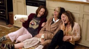 amigas riendo sentadas en el suelo-imagen extraída de una película