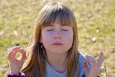 Niña meditando con manos en mudra