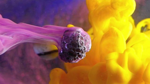 imagen abstracta de un virus rodeado de nubes de humo lila y amarillo