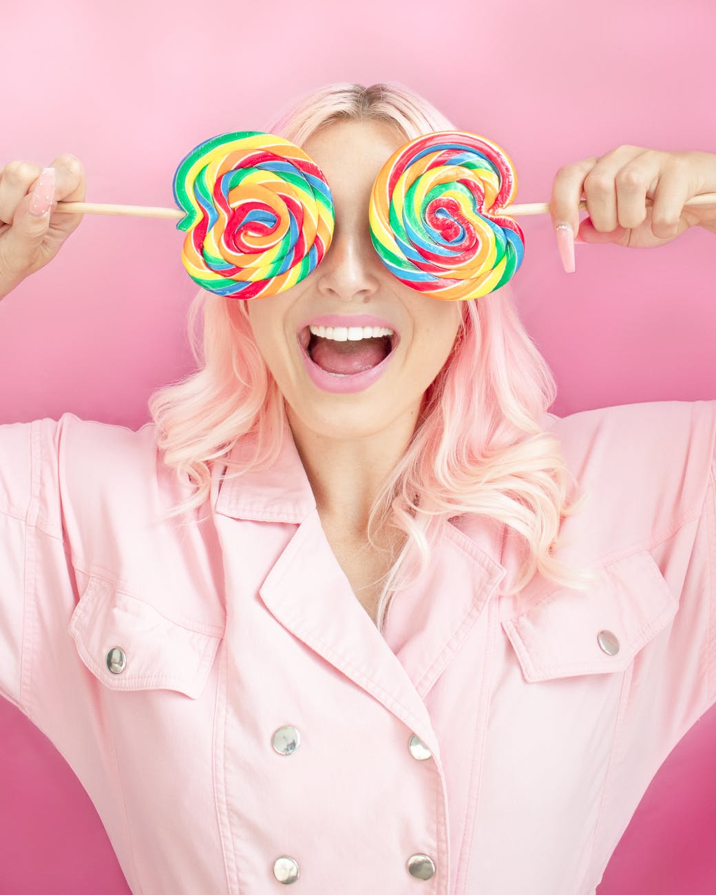 mujer con piruletas de colores delante ojos