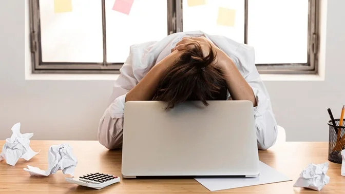 sindrome del burnout-mujer-oficina-manos en la cabeza destrozada-Metodo Sanate